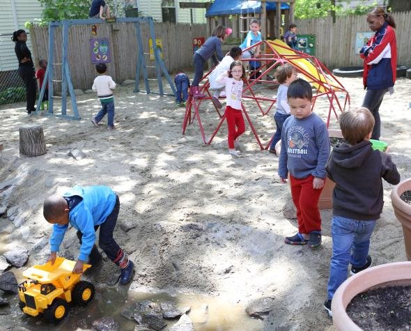 Kids having fun playing outside while teachers help